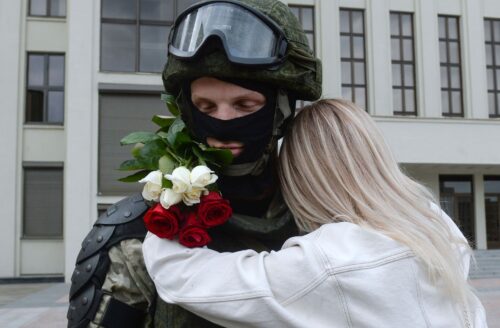 Женщина обнимает спецназовца под МВД Беларуси во время митинга в Минске
