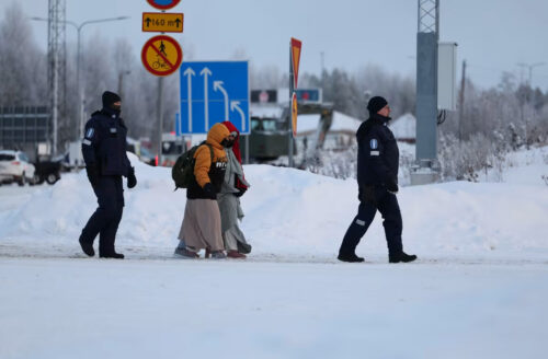 Мигранты в сопровождении финских пограничников на КПП Вартиус, Финляндия.