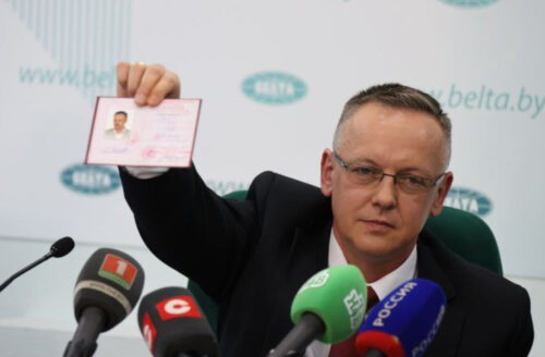 Томаш Шмидт демонстрирует свой польский паспорт на пресс-конференции в Минске
