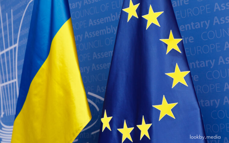 Flags of Ukraine and Europe in front of PACE branding at the Palais de l’Europe.